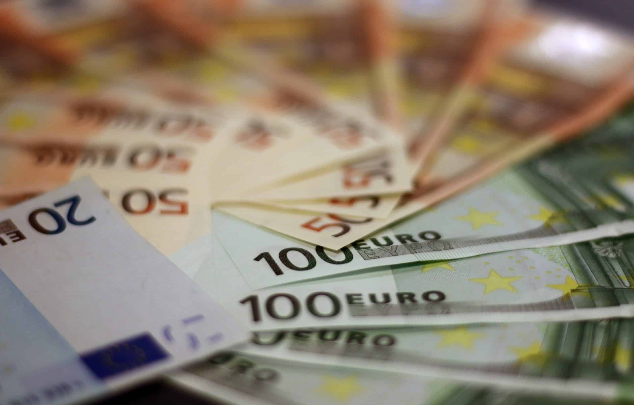 Verschiedene Euro-Banknoten, die fächerförmig auf einem Tisch angeordnet sind.