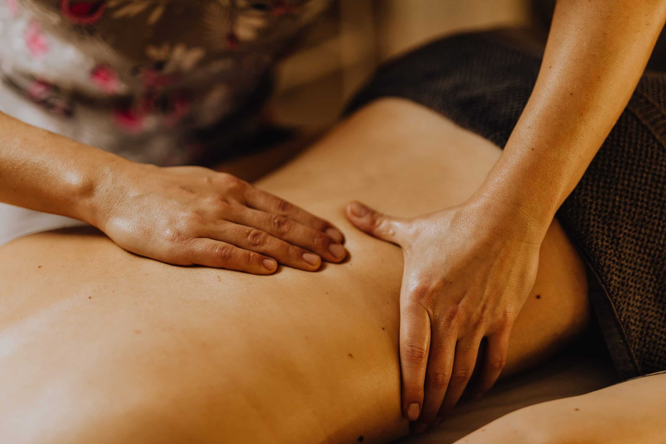 Hände, die eine Shiatsu-Behandlung auf einem Rücken durchführen, als Teil eines therapeutischen Kurses oder Workshops.