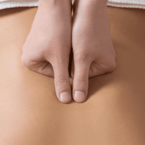 Hände drücken auf den Rücken einer Person während einer Shiatsu-Behandlung, um Entspannung und Wohlbefinden zu fördern.