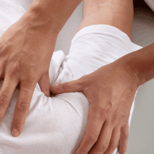 Shiatsu-Therapeut legt Hände auf Rücken einer Person für eine entspannende Behandlung.