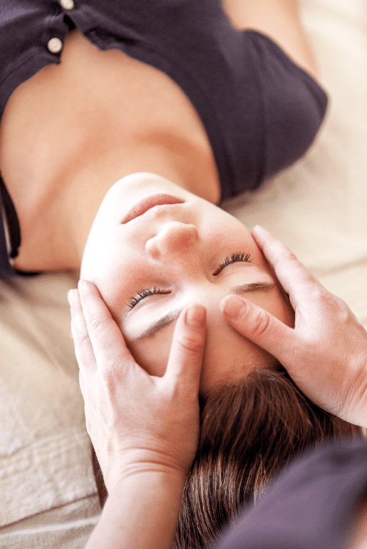 Person erhält entspannende Shiatsu-Behandlung, Hände massieren sanft ihren Kopf für Entspannung und Wohlbefinden.
