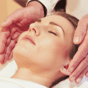 Person genießt Shiatsu-Behandlung, zwei Hände nahe Gesicht, entspannende Wellness-Atmosphäre.