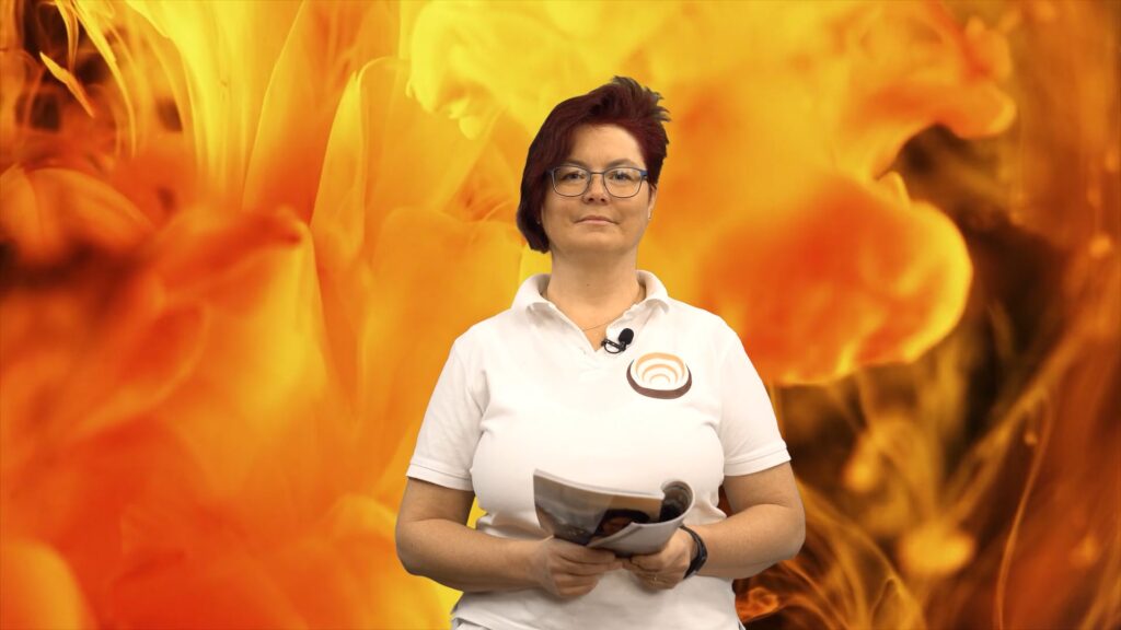 Eine Person im weißen Polohemd präsentiert ein Magazin vor einem leuchtenden, abstrakten, orangenen Hintergrund.