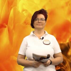 Eine Person im weißen Polohemd präsentiert ein Magazin vor einem leuchtenden, abstrakten, orangenen Hintergrund.